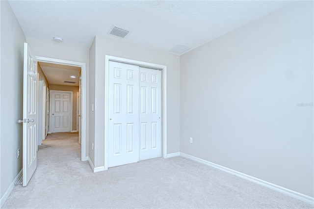 7077 Woodchase Glen Dr, Riverview, FL 33578 - unfurnished bedroom with light colored carpet, a closet, and a textured ceiling