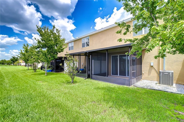 7077 Woodchase Glen Dr, Riverview, FL 33578 - back of house with stucco siding, a sunroom, and a lawn