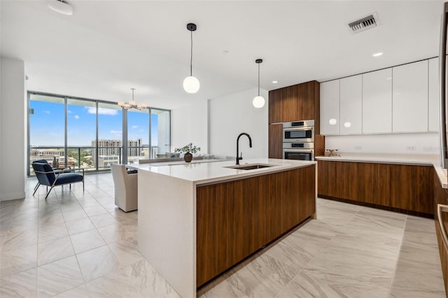 777 3rd Ave N Unit 1406, Saint Petersburg, FL 33701 - kitchen with floor to ceiling windows, modern cabinets, light countertops, white cabinetry, and light marble finish floors