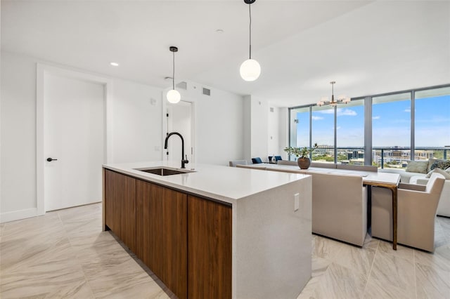 777 3rd Ave N Unit 1406, Saint Petersburg, FL 33701 - kitchen featuring a chandelier, an island with sink, light marble finish floors, open floor plan, and light countertops
