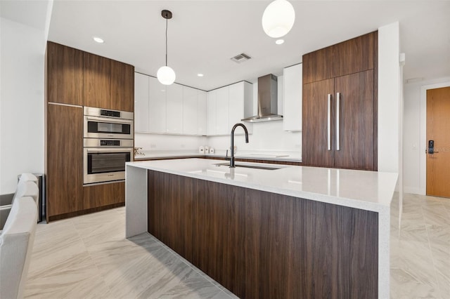 777 3rd Ave N Unit 1406, Saint Petersburg, FL 33701 - kitchen featuring wall chimney range hood, double oven, modern cabinets, white cabinetry, and decorative light fixtures