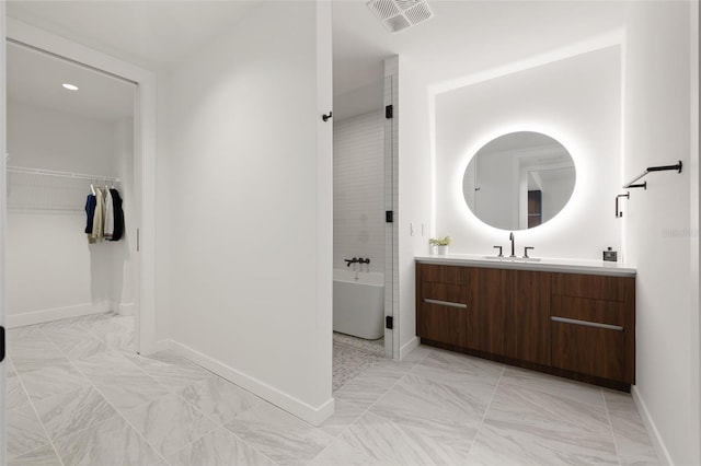 777 3rd Ave N Unit 1406, Saint Petersburg, FL 33701 - bathroom featuring a freestanding bath, vanity, marble look tiles, and a spacious closet