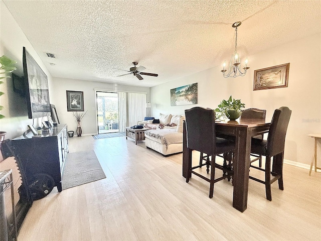 10636 Millriver Dr, New Port Richey, FL 34654 - dining area with a textured ceiling, a ceiling fan, light wood-style flooring, and a chandelier