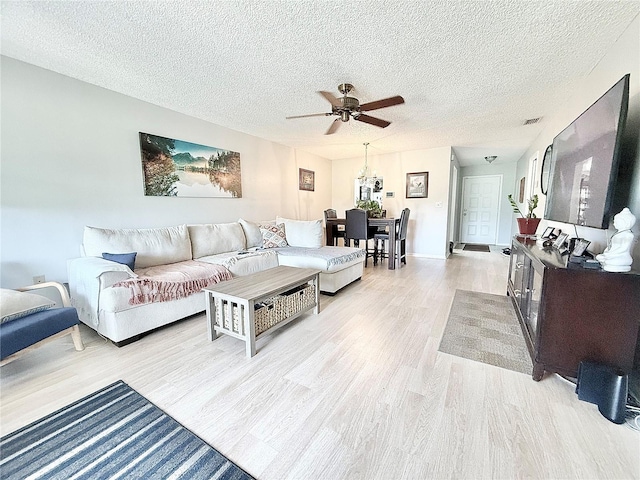 10636 Millriver Dr, New Port Richey, FL 34654 - living room with light wood-style flooring, ceiling fan, and a textured ceiling
