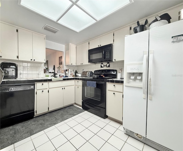10636 Millriver Dr, New Port Richey, FL 34654 - kitchen featuring black appliances, tile counters, and backsplash