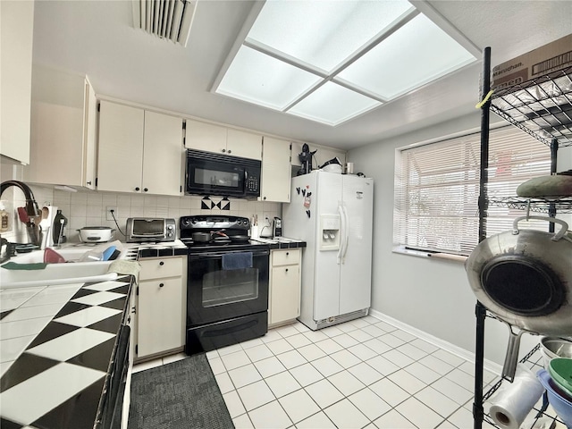 10636 Millriver Dr, New Port Richey, FL 34654 - kitchen featuring black appliances, tile countertops, decorative backsplash, and light tile patterned floors