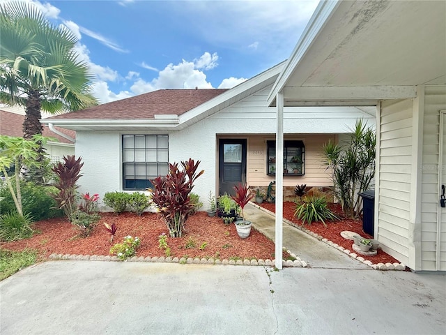 10636 Millriver Dr, New Port Richey, FL 34654 - entrance to property featuring a shingled roof and stucco siding