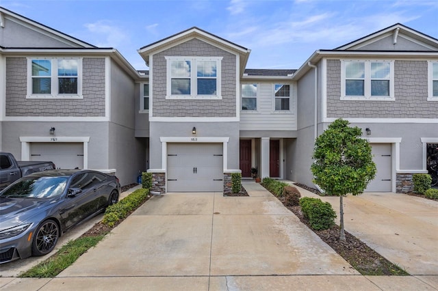 5813 Grand Sonata Ave, Lutz, FL 33558 - townhome / multi-family property with stucco siding, an attached garage, concrete driveway, and stone siding