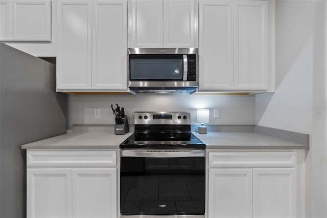 5813 Grand Sonata Ave, Lutz, FL 33558 - kitchen with stainless steel appliances, white cabinetry, light countertops, and tile patterned floors
