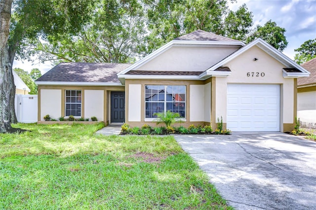 6720 Gilda Dr, Tampa, FL 33625 - ranch-style house with stucco siding, concrete driveway, a garage, and roof with shingles