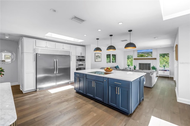 4096 38th St S, Saint Petersburg, FL 33711 - kitchen with built in fridge, blue cabinets, white cabinetry, wood finished floors, and light countertops