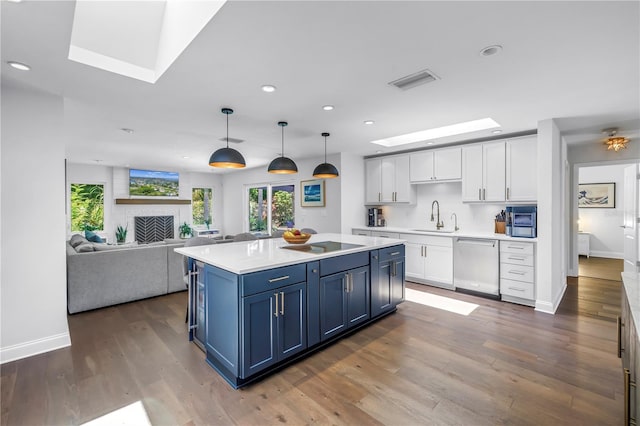 4096 38th St S, Saint Petersburg, FL 33711 - kitchen with stainless steel dishwasher, a skylight, white cabinetry, light countertops, and plenty of natural light
