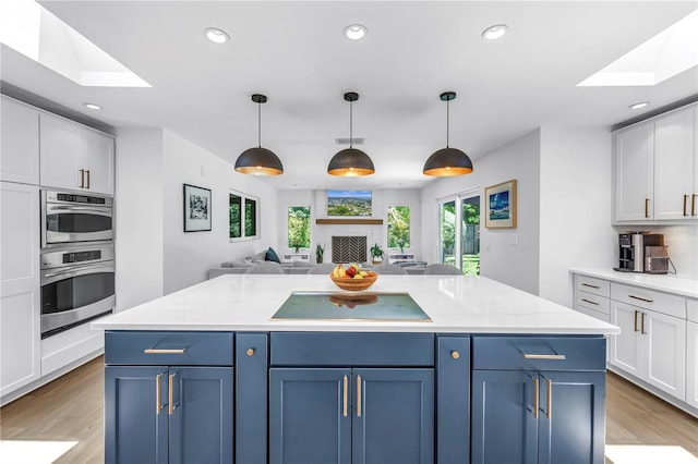 4096 38th St S, Saint Petersburg, FL 33711 - kitchen with stovetop, a skylight, open floor plan, white cabinets, and recessed lighting