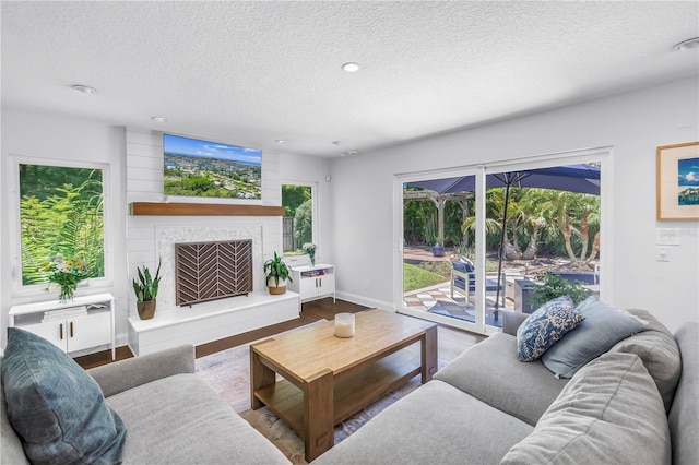 4096 38th St S, Saint Petersburg, FL 33711 - living room featuring a textured ceiling, a large fireplace, recessed lighting, and wood finished floors