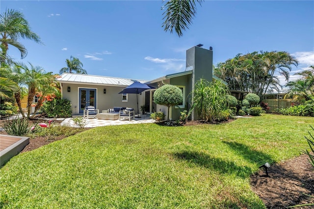 4096 38th St S, Saint Petersburg, FL 33711 - rear view of property with french doors, outdoor lounge area, stucco siding, a lawn, and a patio area