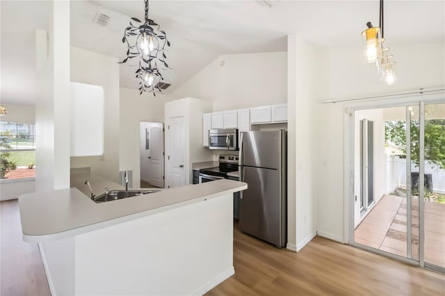 818 Cherry Laurel St, Minneola, FL 34715 - kitchen featuring stainless steel appliances, a chandelier, light wood finished floors, white cabinets, and pendant lighting