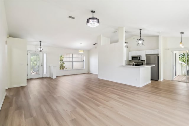 818 Cherry Laurel St, Minneola, FL 34715 - unfurnished living room with light wood-type flooring, a chandelier, and high vaulted ceiling