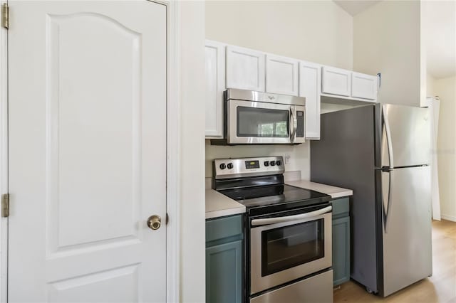 818 Cherry Laurel St, Minneola, FL 34715 - kitchen with stainless steel appliances, light countertops, white cabinetry, and light wood-style floors