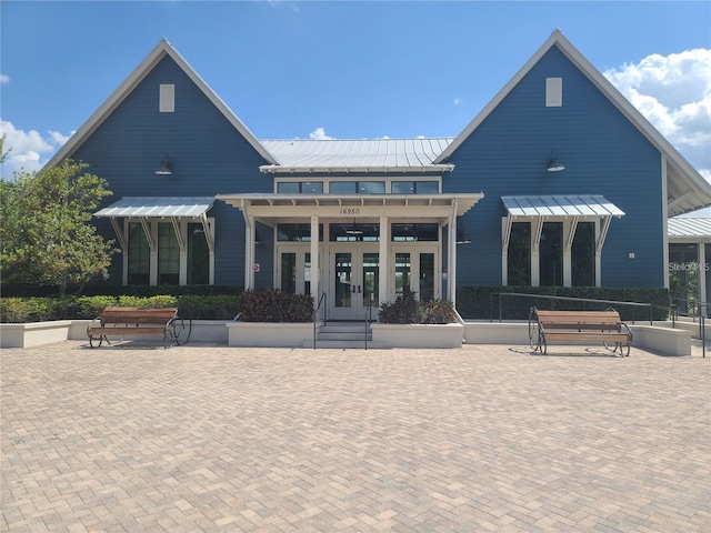 18144 Frame Bnd, Land O Lakes, FL 34638 - back of property with french doors, a metal roof, and a standing seam roof