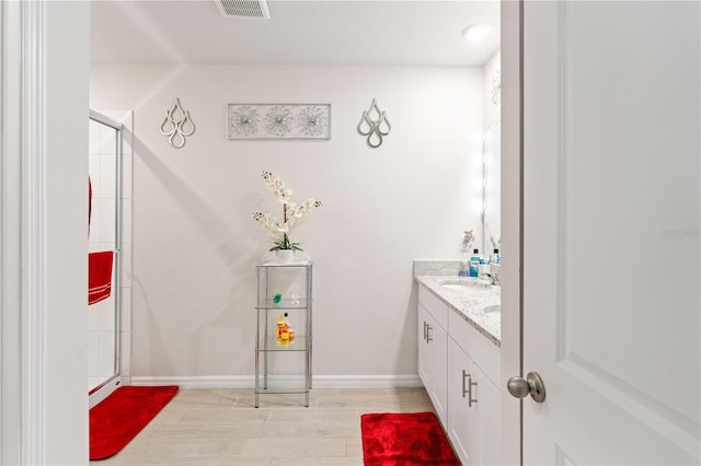 39024 Harlow Rose Dr, Zephyrhills, FL 33540 - full bathroom with vanity, an enclosed shower, and wood finished floors