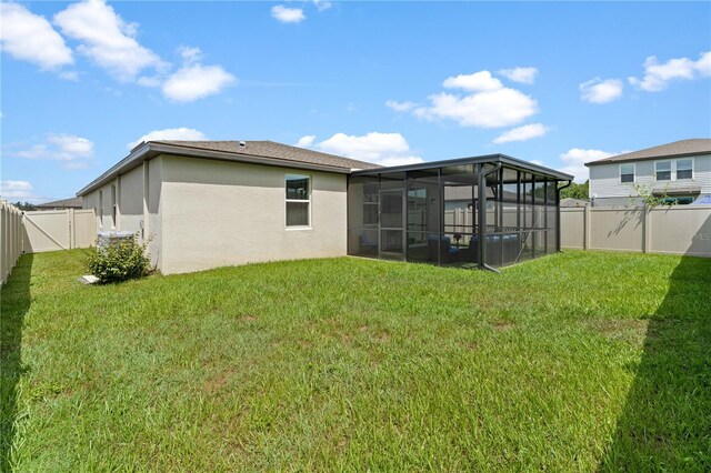39024 Harlow Rose Dr, Zephyrhills, FL 33540 - rear view of property featuring stucco siding, a sunroom, and a fenced backyard