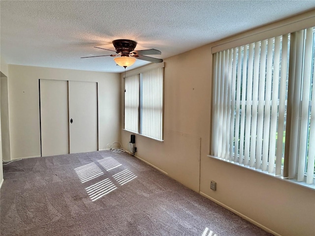 2070 World Parkway Blvd Unit 36, Clearwater, FL 33763 - unfurnished bedroom featuring a closet, carpet flooring, a textured ceiling, and a ceiling fan