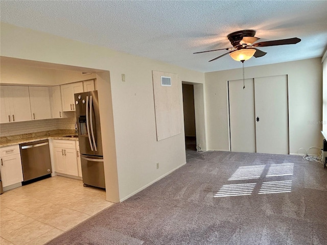 2070 World Parkway Blvd Unit 36, Clearwater, FL 33763 - kitchen with appliances with stainless steel finishes, a ceiling fan, white cabinets, light stone counters, and a textured ceiling