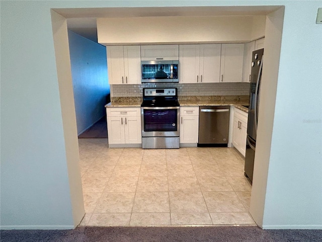2070 World Parkway Blvd Unit 36, Clearwater, FL 33763 - kitchen with stainless steel appliances, backsplash, light stone countertops, and white cabinets