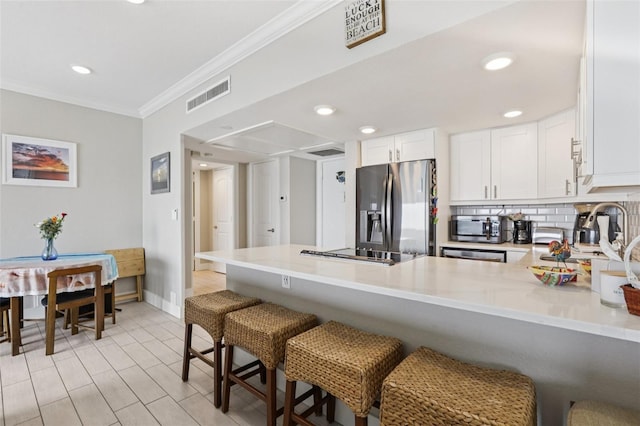 880 Mandalay Ave Unit C513, Clearwater Beach, FL 33767 - kitchen featuring appliances with stainless steel finishes, a peninsula, crown molding, light countertops, and tasteful backsplash