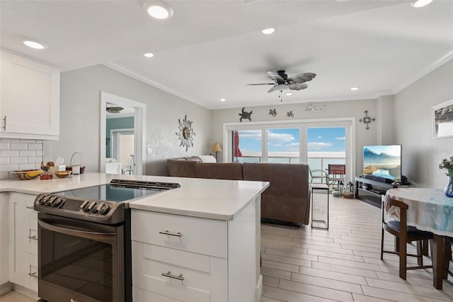 880 Mandalay Ave Unit C513, Clearwater Beach, FL 33767 - kitchen featuring stainless steel electric stove, open floor plan, light countertops, a ceiling fan, and crown molding