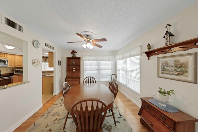 3035 Countryside Blvd Unit 16B, Clearwater, FL 33761 - dining room featuring ceiling fan, light wood-style flooring, and a textured ceiling
