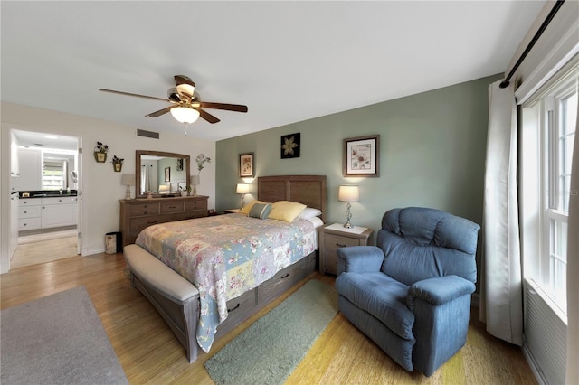 3035 Countryside Blvd Unit 16B, Clearwater, FL 33761 - bedroom with light wood-style floors, a ceiling fan, and connected bathroom