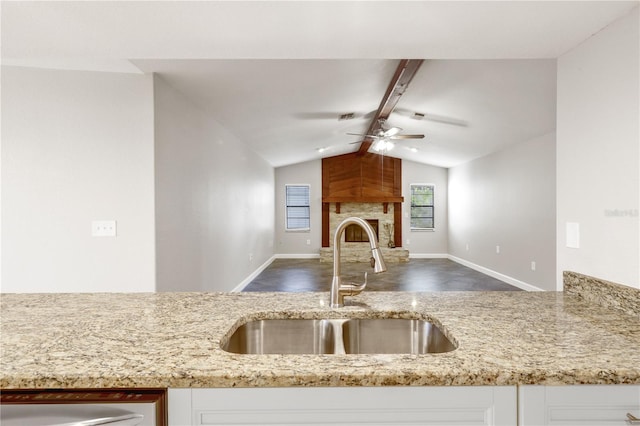 3753 Thornbush Ln, New Port Richey, FL 34655 - kitchen with a ceiling fan, light stone countertops, white cabinetry, open floor plan, and a fireplace