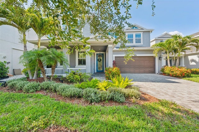 12121 Rustic River Way, Tampa, FL 33635 - view of front of house featuring stucco siding, covered porch, a garage, and decorative driveway