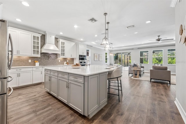 12121 Rustic River Way, Tampa, FL 33635 - kitchen featuring custom exhaust hood, stainless steel appliances, open floor plan, gray cabinets, and an island with sink