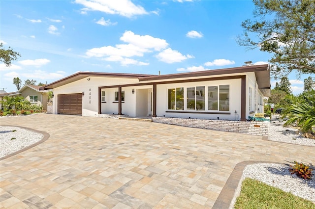 6400 Mockingbird Way S, Saint Petersburg, FL 33707 - ranch-style home featuring decorative driveway, stucco siding, and an attached garage