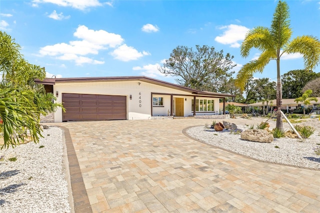 6400 Mockingbird Way S, Saint Petersburg, FL 33707 - view of front facade featuring an attached garage, decorative driveway, and stucco siding