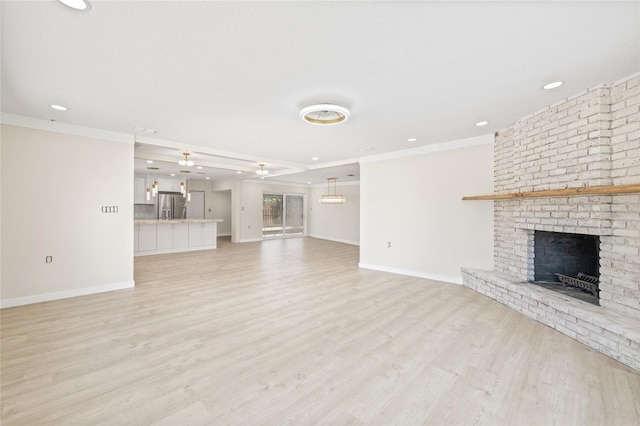 6400 Mockingbird Way S, Saint Petersburg, FL 33707 - unfurnished living room featuring a fireplace, recessed lighting, crown molding, and light wood-style flooring
