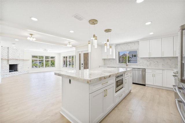 6400 Mockingbird Way S, Saint Petersburg, FL 33707 - kitchen featuring appliances with stainless steel finishes, recessed lighting, light wood-type flooring, decorative backsplash, and open floor plan