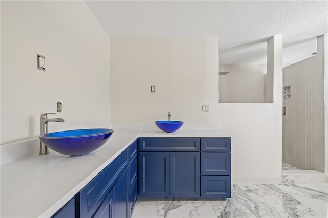 6400 Mockingbird Way S, Saint Petersburg, FL 33707 - bathroom featuring marble finish floors, vanity, a walk in shower, and a textured ceiling