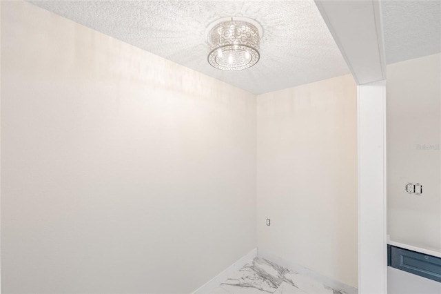 6400 Mockingbird Way S, Saint Petersburg, FL 33707 - washroom featuring a textured ceiling, a chandelier, and light marble finish flooring