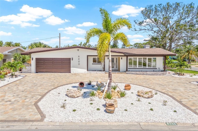 6400 Mockingbird Way S, Saint Petersburg, FL 33707 - single story home with a garage, decorative driveway, and stucco siding