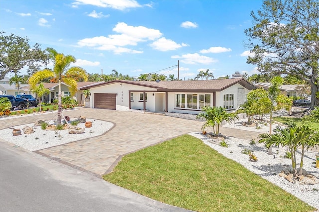 6400 Mockingbird Way S, Saint Petersburg, FL 33707 - single story home featuring decorative driveway, a garage, a front yard, and stucco siding