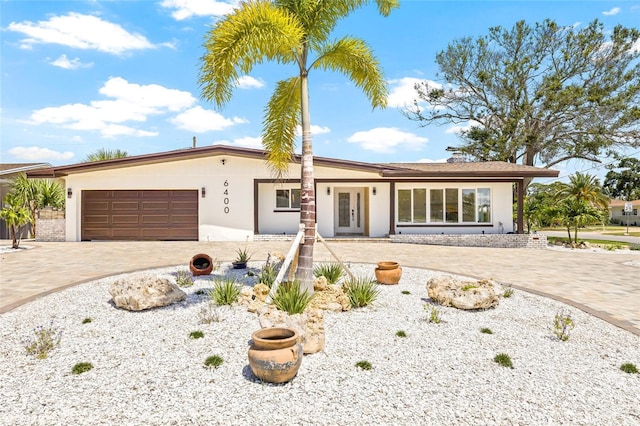 6400 Mockingbird Way S, Saint Petersburg, FL 33707 - ranch-style home featuring an attached garage, decorative driveway, stucco siding, and french doors