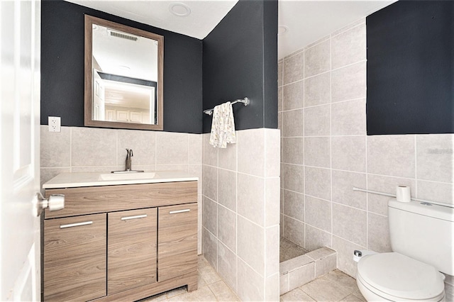 4928 Petunia Ct, New Port Richey, FL 34652 - bathroom featuring tile walls, vanity, tile patterned flooring, and tiled shower