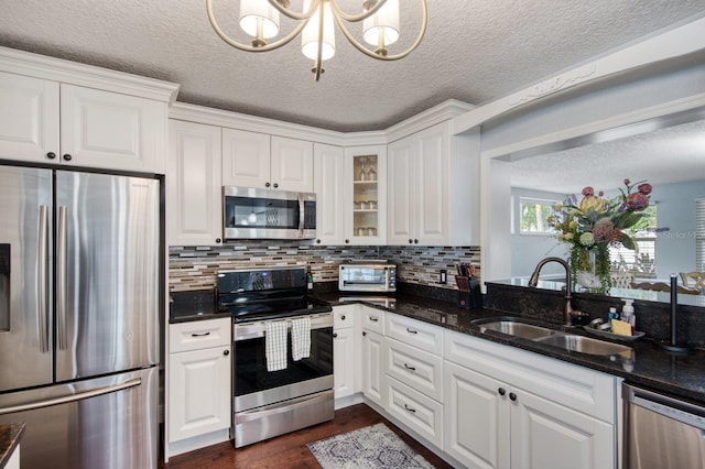 3173 Fountainhead Dr, Largo, FL 33770 - kitchen featuring stainless steel appliances, white cabinetry, dark wood-style flooring, a textured ceiling, and a chandelier