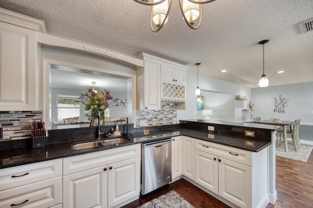 3173 Fountainhead Dr, Largo, FL 33770 - kitchen with dishwasher, a peninsula, decorative backsplash, white cabinets, and a textured ceiling
