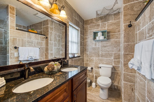 3173 Fountainhead Dr, Largo, FL 33770 - full bath featuring tile walls, a textured ceiling, double vanity, and tiled shower