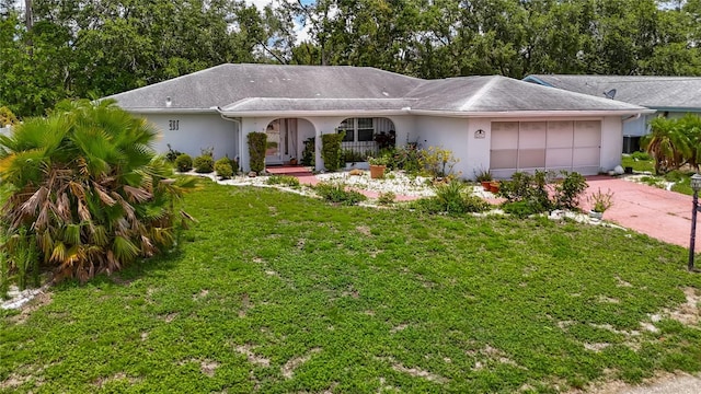 1607 New Bedford Dr, Sun City Center, FL 33573 - ranch-style house featuring stucco siding, an attached garage, a front yard, and concrete driveway
