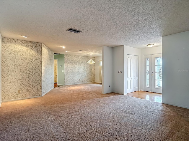 1607 New Bedford Dr, Sun City Center, FL 33573 - unfurnished room featuring carpet, wallpapered walls, and a textured ceiling